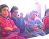 In unaula sono riuniti tutti gli alunni della scuola. Panoramica dellaula e dei ragazzi, silenziosi e attenti...