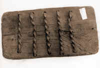 25. Stregarla (trebbiatrice a mano) di Anonimo. Ferro e legno, Ia met sec. XX, largh. cm 21,5, lungh. cm 40,5 (utilizzata per trebbiare ju manntu dalle spigarle (spigolatrici), donne di famiglia che seguivano il mietitore per raccogliere in mazzetti (mannti) le spighe che gli cadevano. Ji mannti venivano poi trebbiati la sera, dopo che le spighe si erano scaldate al sole. Quella de lo raccapezz (raccogliere le spighe cadute) era un'antica consuetudine, preziosa per le famiglie contadine e per le giovani spose, che ne ricavavano qualcosa per la dote. Il termine stregarla deriva probabilmente dal latino extricare, tirar fuori, cavare.