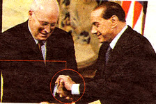 2008: il Berlusconi abbottona i polsini di Dick Cheney. Umiliante? No, lui sa su chi rifarsi.