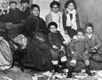 17. Migranti italiani attendono con i bambini in un ufficio che ci si occupi di loro.